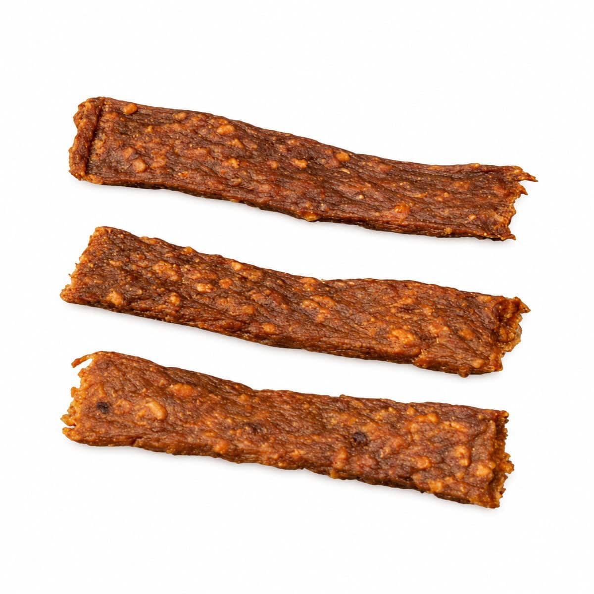 Drie gedroogde kalkoenvleesstrips op een witte achtergrond.