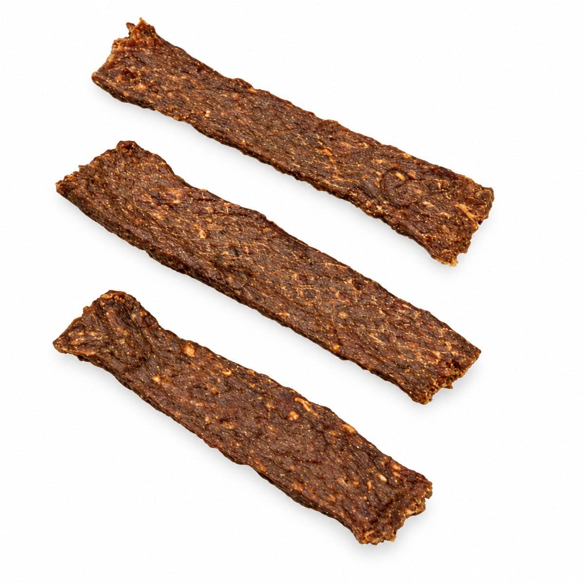 Drie gedroogde vleesstrips op een witte achtergrond.